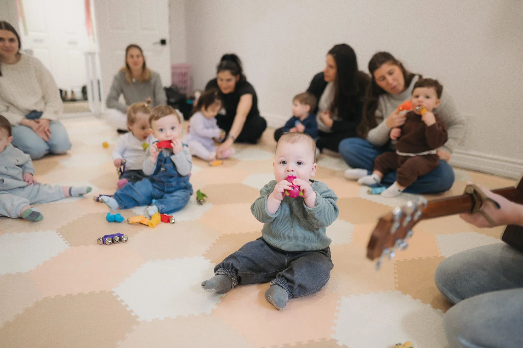 Babies in a large circle with instruments and Rachel's guitar at Rockin' with Rach Toronto
