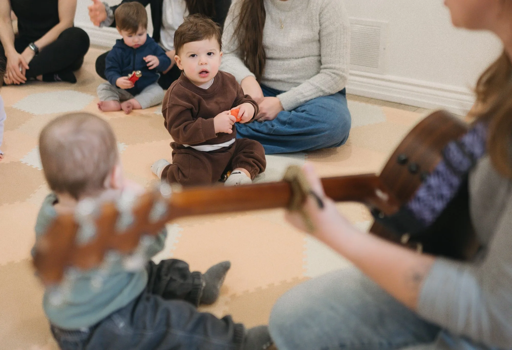 Babies with instruments and guitar in the foreground at Rockin' with Rach Toronto studio