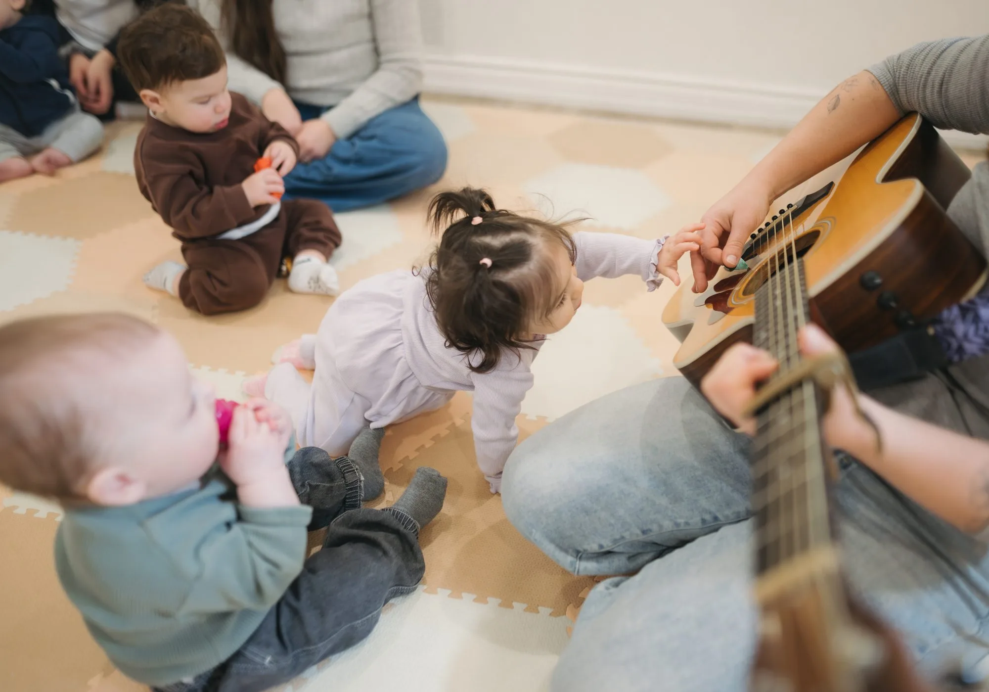 Babies reaching up to touch Rachel's guitar strings at Rockin' with Rach Toronto