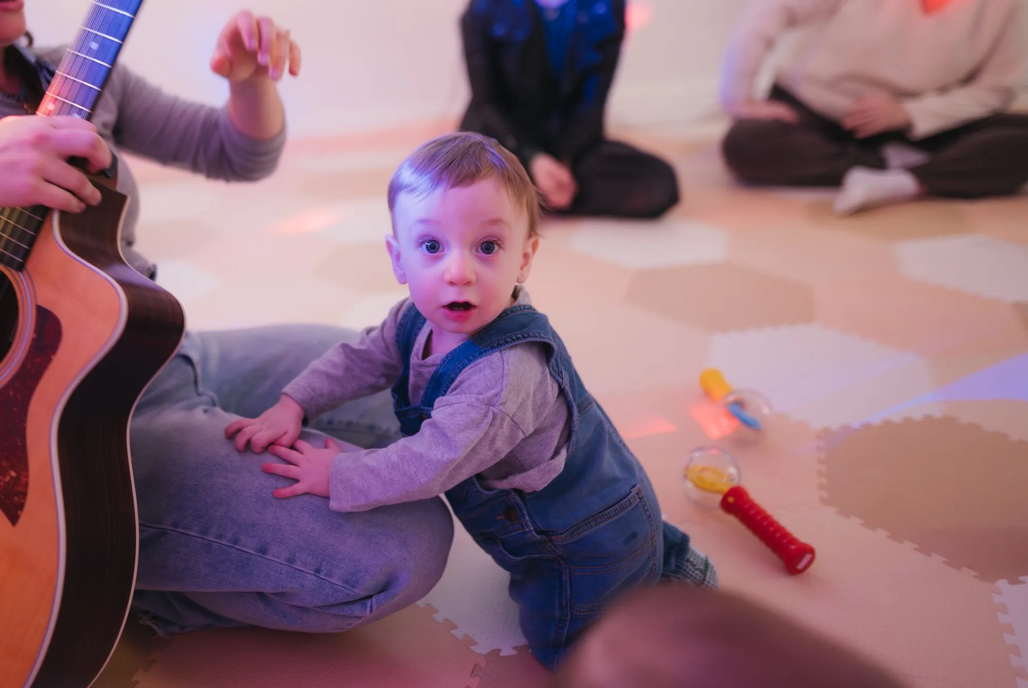 Curious baby boy sitting beside Rachel's guitar at Rockin' with Rach studio Toronto