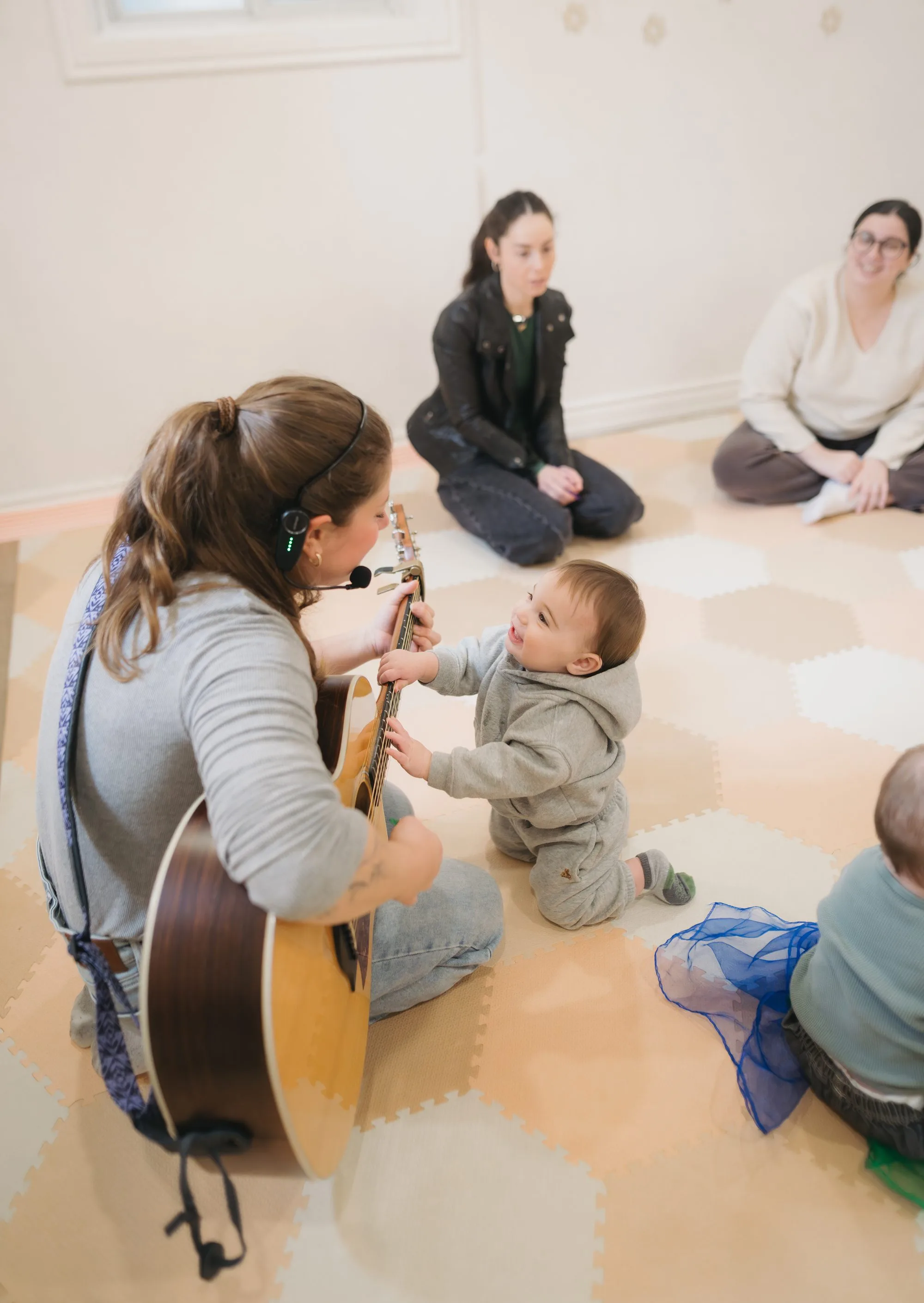 Baby exploring guitar strings up close at Rockin' with Rach baby music class Toronto