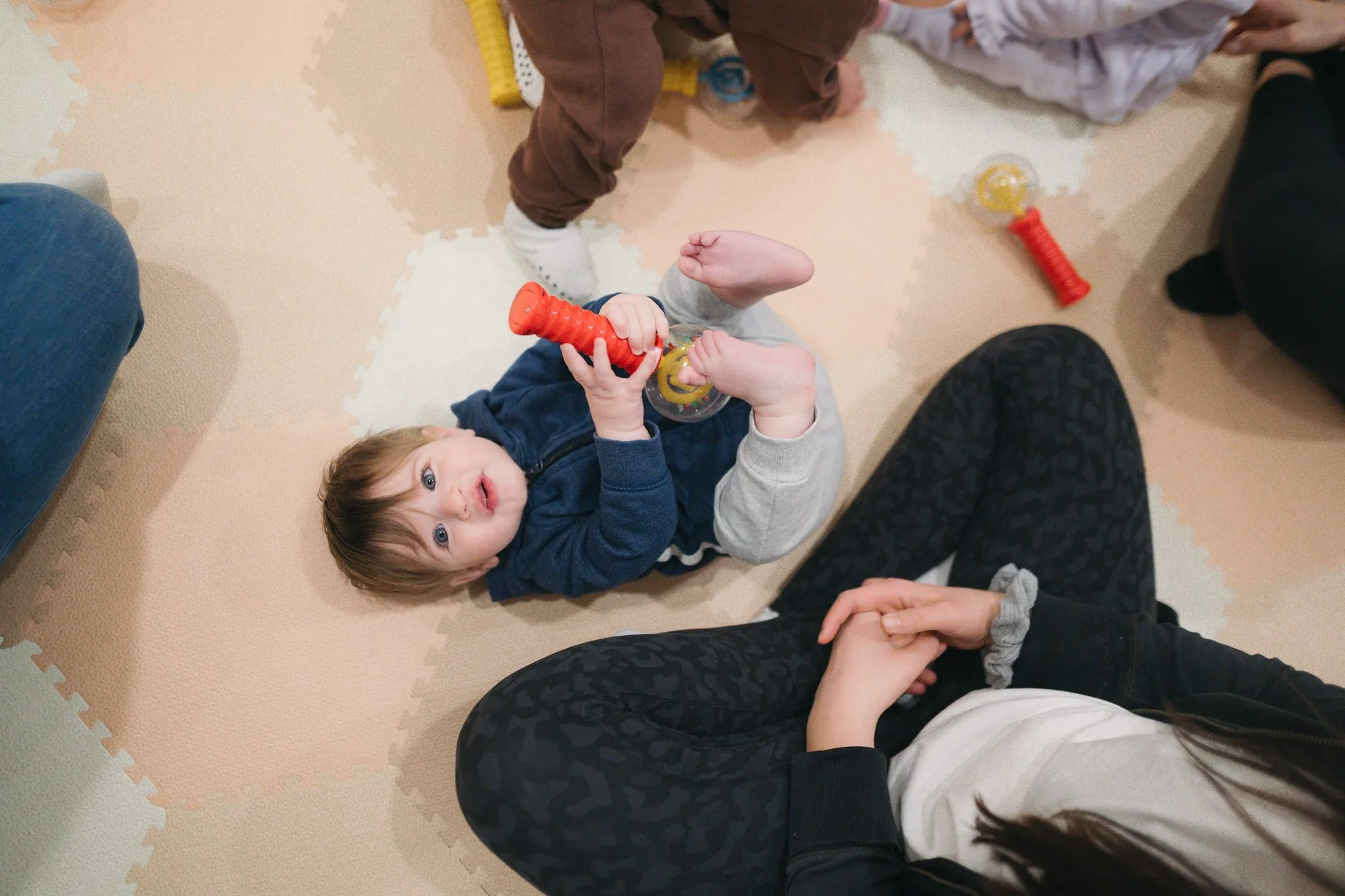 Baby holding maracas and looking up with curiosity at Rockin' with Rach Toronto
