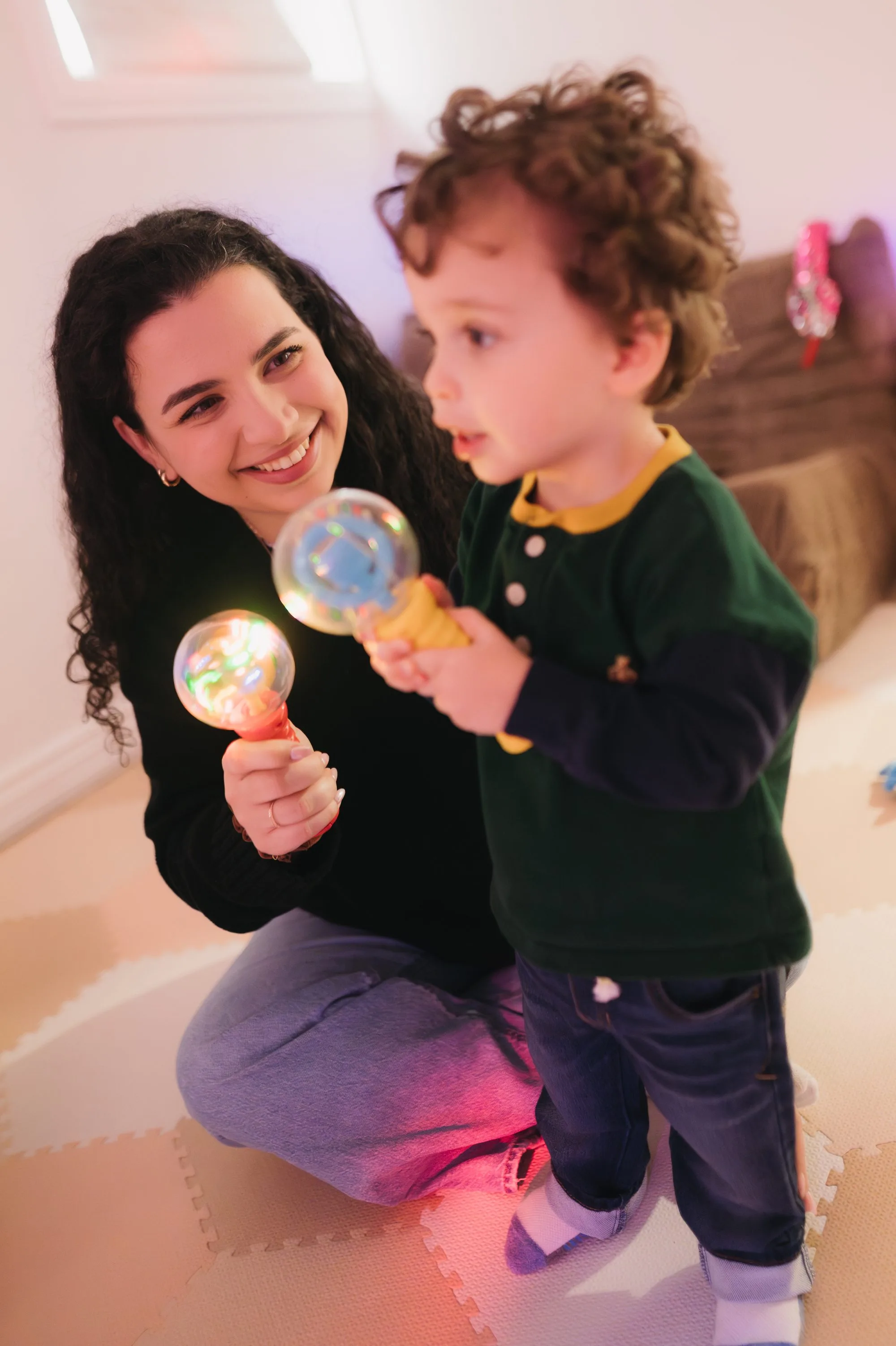 Caregiver and toddler enjoying a light show during a Rockin' with Rach music class