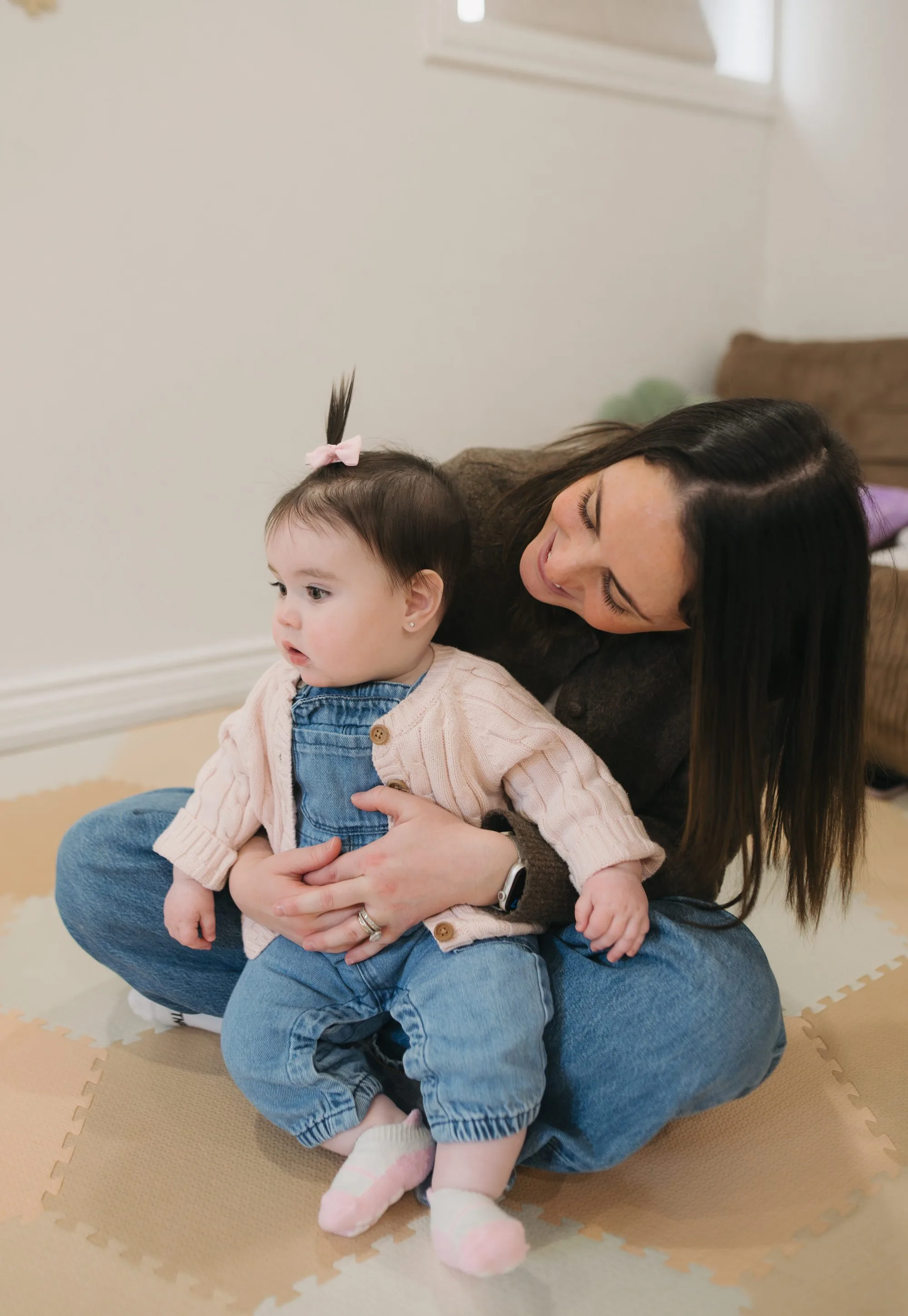 Mom bonding with baby girl in pink bow during a Rockin' with Rach music class