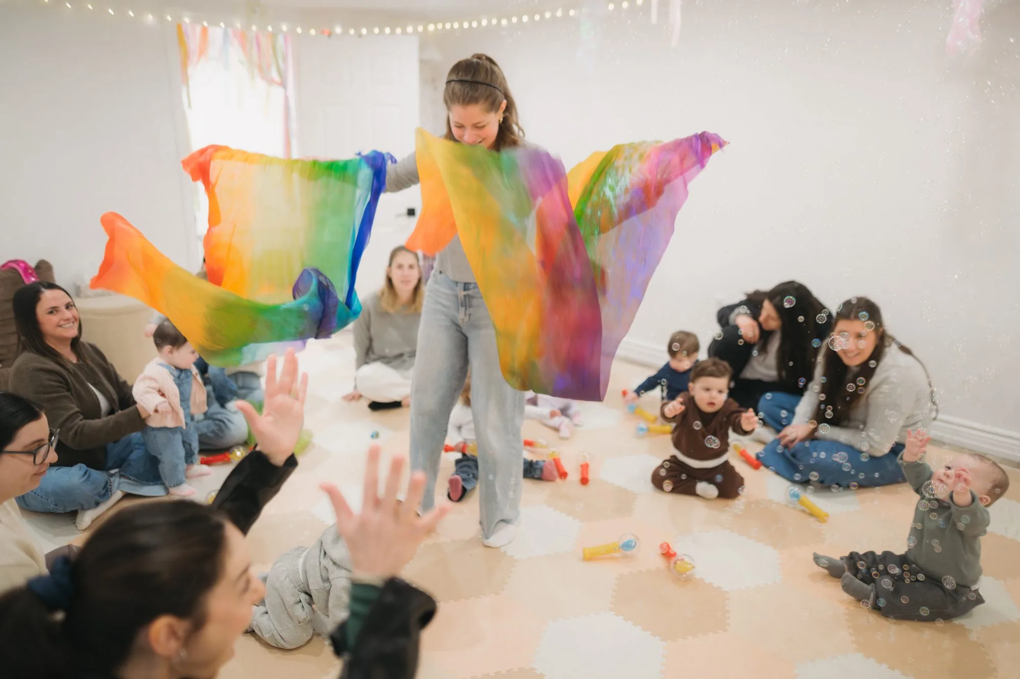 Rachel filling the studio with large rainbow scarves and floating bubbles at Rockin' with Rach Toronto