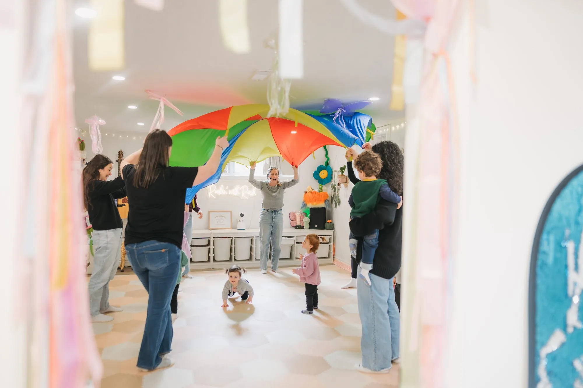 Rachel leading a parachute activity viewed from the studio doorway at Rockin' with Rach Toronto