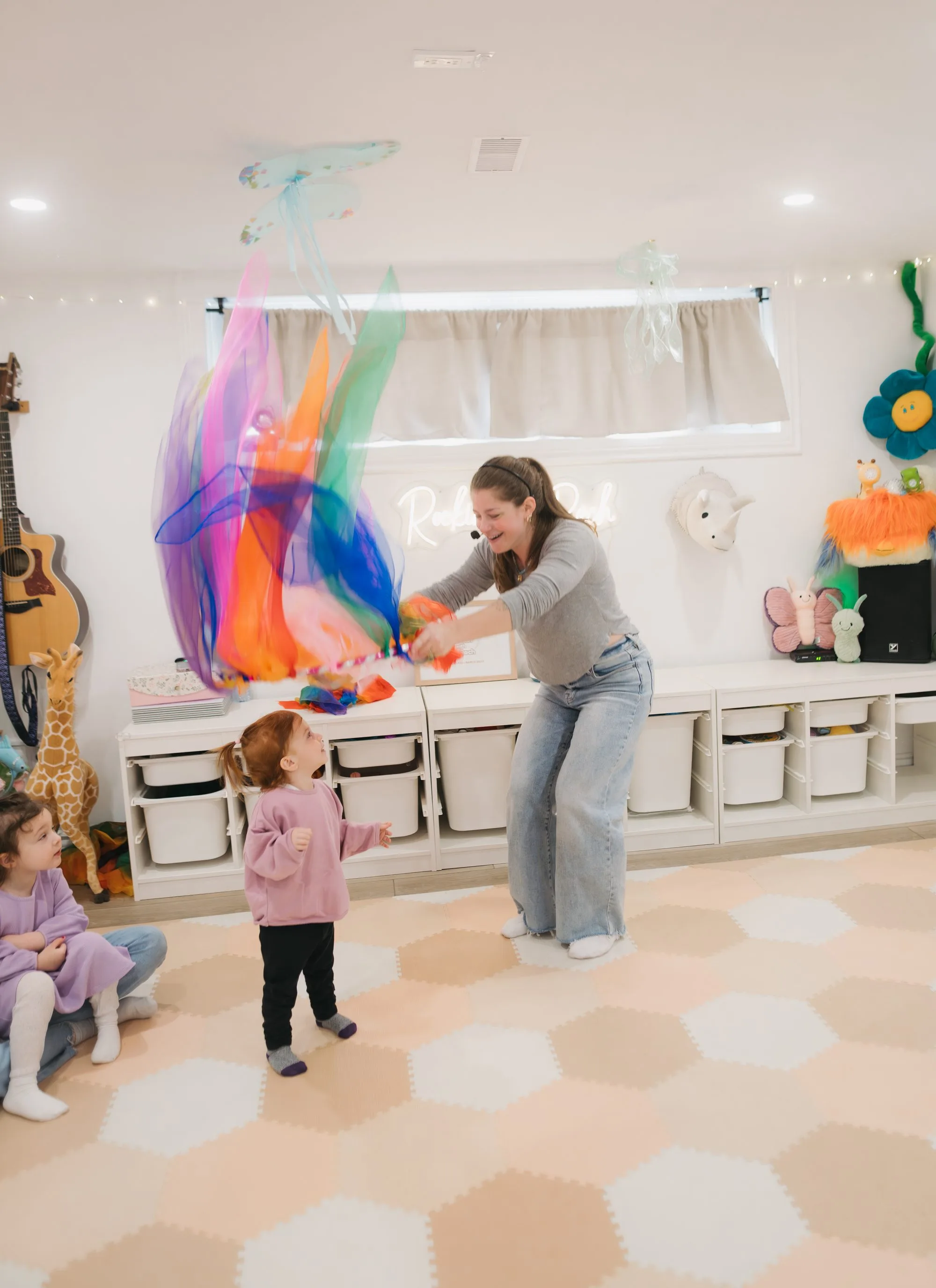 Rachel leading a rainbow scarf activity with a toddler at Rockin' with Rach Toronto