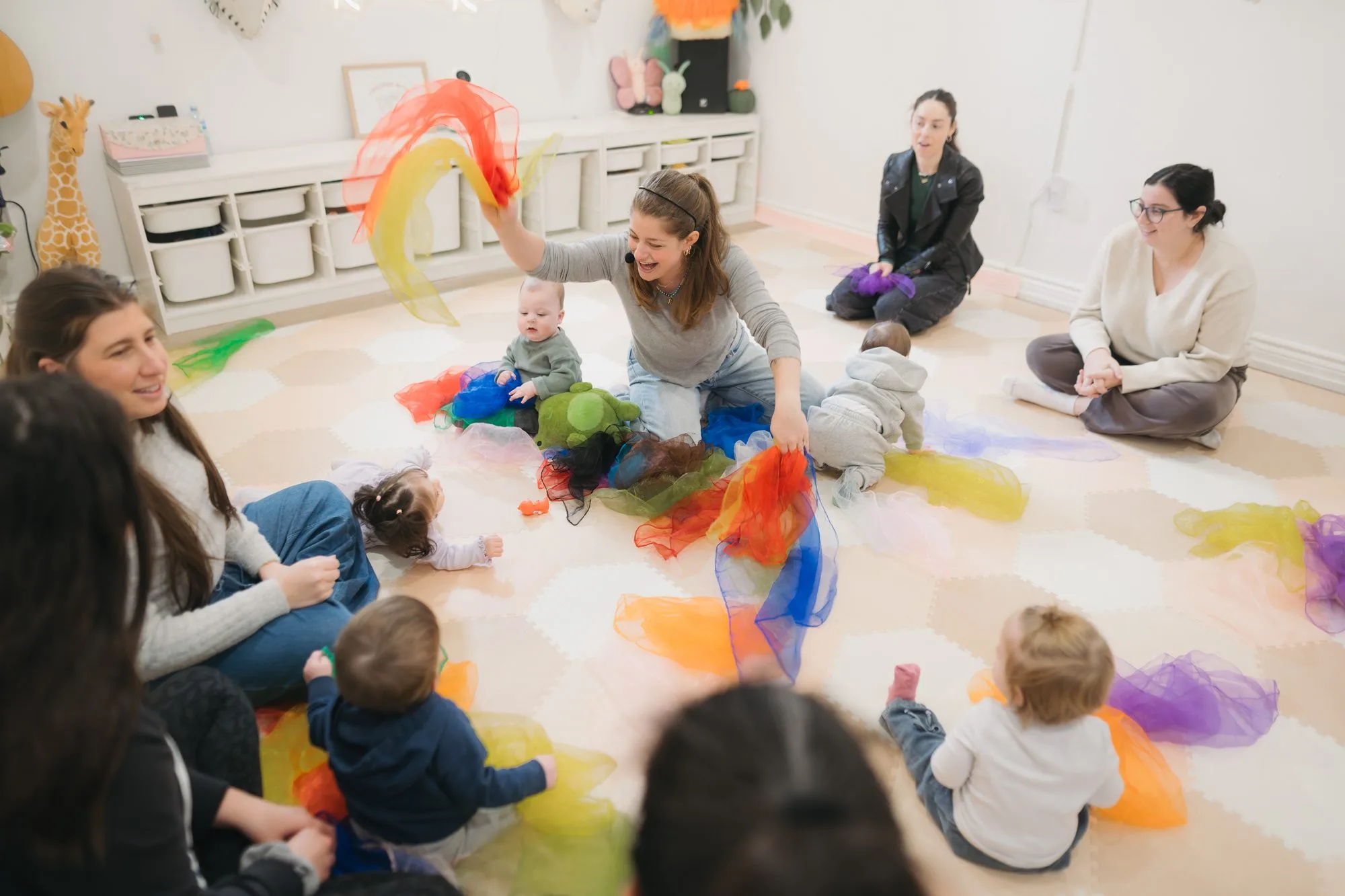 Rachel waving rainbow scarves as babies watch at Rockin' with Rach music class Toronto