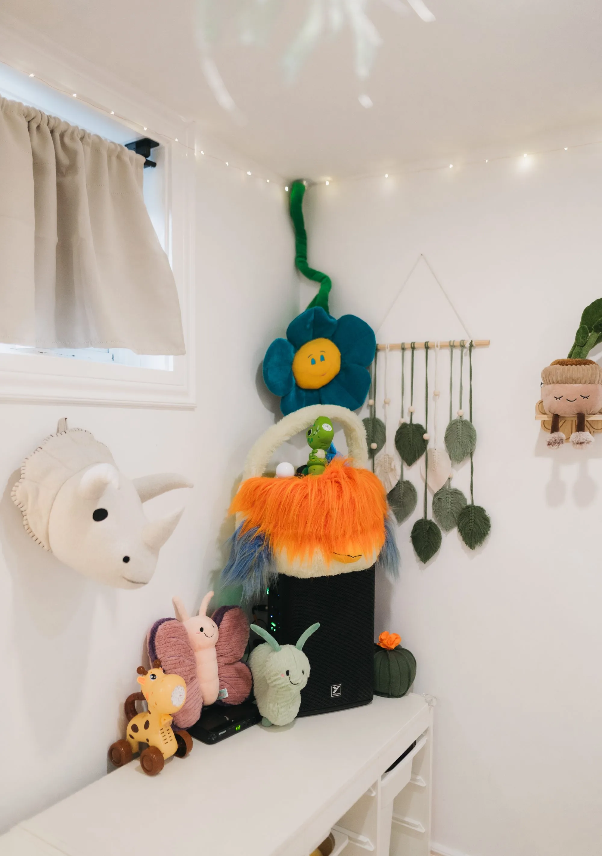 Colourful toys and macrame wall decor in the corner of Rockin' with Rach studio Toronto