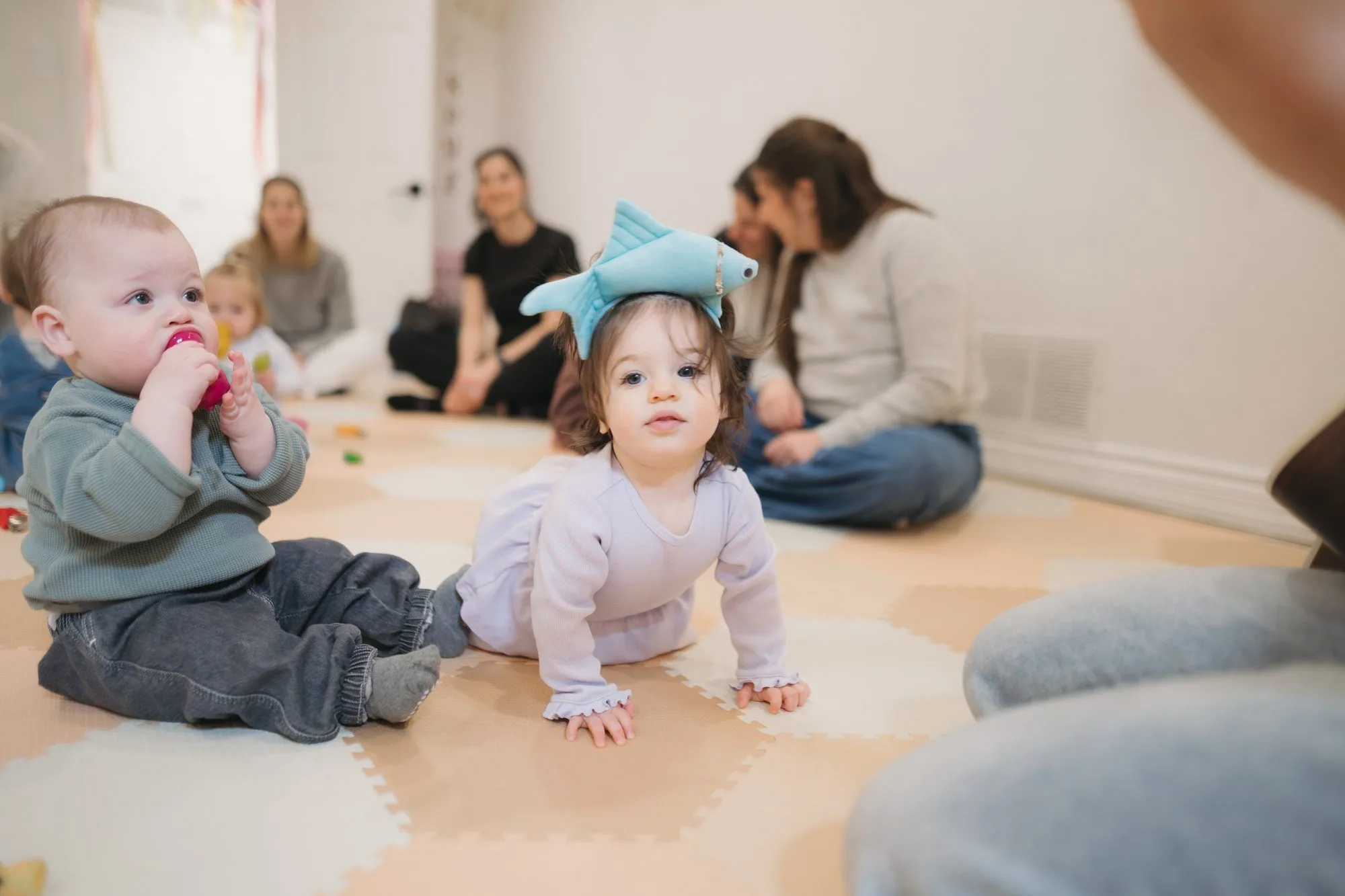 Toddler girl laughing with rainbow scarves at Rockin' with Rach Toronto