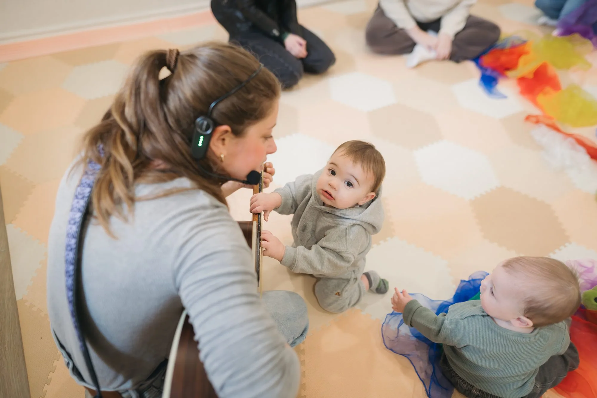 Two babies exploring Rachel's guitar strings together at Rockin' with Rach music class Toronto